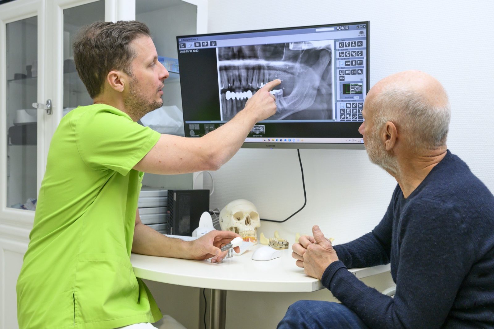 Dr. Hergt zeigt einem Patienten den 3D-Befund am Bildschirm - DVT in der Praxis Oralchirurgie & Implantologie Templin